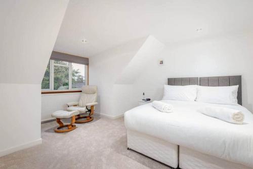 een witte slaapkamer met een groot bed en een raam bij Greentiles - Spacious House - Extensive Garden - Convenient Location in St Andrews