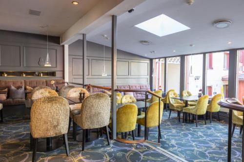 a restaurant with yellow chairs and tables in a room at Home Hotel Kung Oscar in Trollhättan