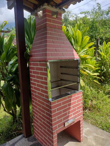 um forno de tijolo ao ar livre sentado num jardim em Casa praias de São Gonçalo em Paraty RJ em Paraty