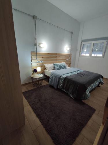 a bedroom with a large bed and a rug at Playa de Carnota Lofts in Pedrafigueira