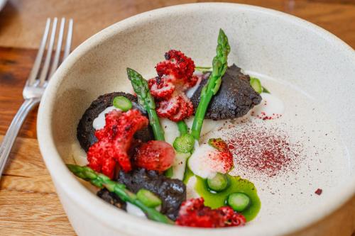 a white bowl of food with berries and green beans at Huinid Bustillo Hotel & Spa in San Carlos de Bariloche