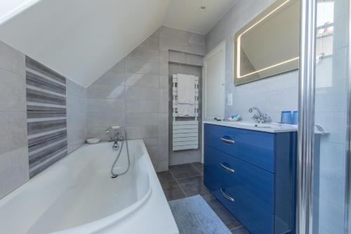 オルレアンにあるZenBreak Suite Turnerのバスルーム(青いキャビネット、バスタブ、シンク付)
