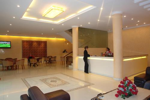 a woman standing at a counter in a hotel lobby at Dreamliner Hotel in Addis Ababa