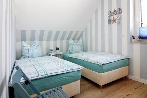 2 Einzelbetten in einem kleinen Zimmer mit gestreiften Wänden in der Unterkunft Semi-detached house Dock No- 7-0 Zirchow - DOS081jai-L in Zirchow