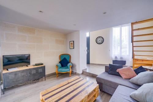 un salon avec un canapé et une télévision dans l'établissement Belle maison de ville Bordeaux Talence, à Talence