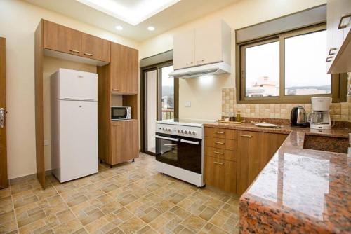 a kitchen with a refrigerator and a stove top oven at Delmare 3BR Apartment in Batroun in Batroûn