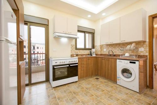 a kitchen with a washer and dryer in it at Akl - Chic Apartments & Balconies in Batroun in Batroûn