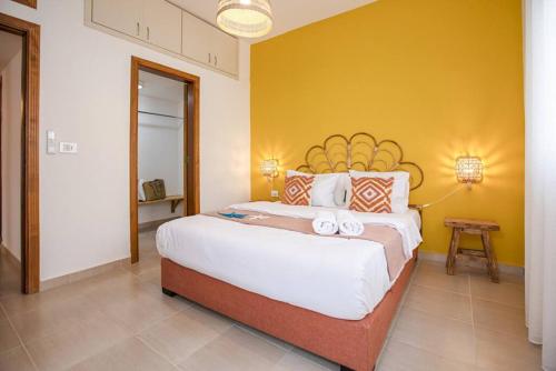 a bedroom with a large bed with a yellow wall at Delmare 3BR Apartment in Batroun in Batroûn