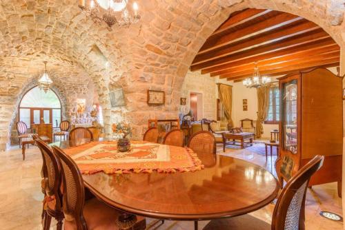 uma grande sala de jantar com mesa e cadeiras em Authentic Villa with Pool and Garden in Beit Chabeb 