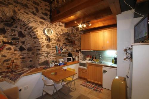a kitchen with wooden cabinets and a stone wall at Mesta Loft in Mesta