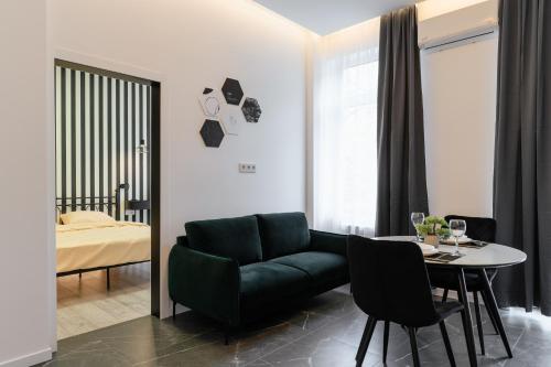 Luxury Apartments Laborca في أوجهورود: غرفة معيشة مع أريكة خضراء وطاولة