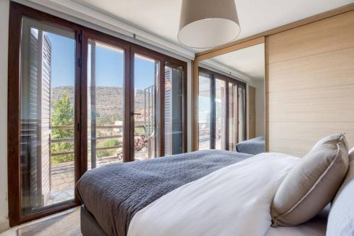 a bedroom with a bed with a large window at Hert 3Bedroom Villa In Faraya in Brummānā