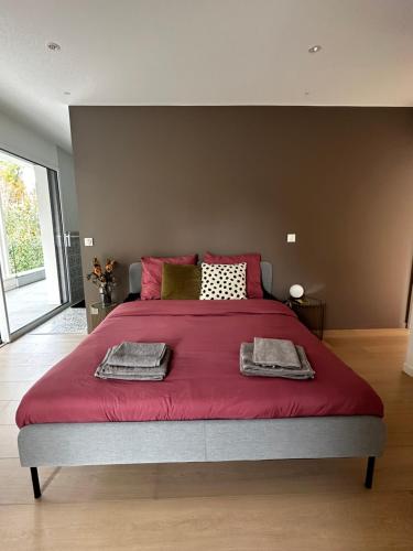 - une chambre avec un grand lit et une couverture rouge dans l'établissement Villa d'architecte entre lac et montagnes, à Saint-Alban