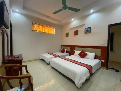 2 bedden in een kamer met een plafondventilator bij ANH ĐÀO HOTEL LẠNG SƠN in Lạng Sơn