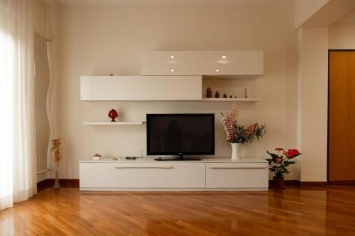 una sala de estar con TV en un centro de entretenimiento blanco en I due ponti, en Molfetta
