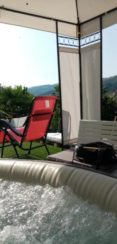 a patio with a hot tub and a chair and a table at La casa di Mia in Perino