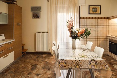 una cocina con una mesa con un jarrón de flores. en I due ponti, en Molfetta