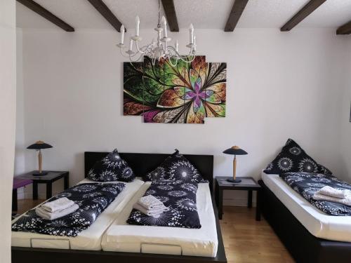 una sala de estar con 2 sofás y una pintura en la pared en Pension & Appartments Landhaus Bettina Fulda, en Fulda