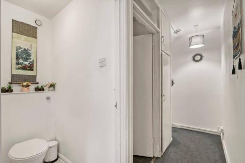 a white bathroom with a toilet and a door at Peaceful 2-Bed South Bank in London
