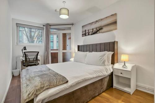 a bedroom with a bed and a desk and a window at Peaceful 2-Bed South Bank in London