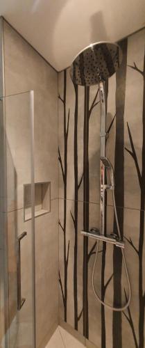 La salle de bains est pourvue d'une douche et d'une peinture d'arbres. dans l'établissement Gîte & Spa le Clos de Mon Père, à Rochefort