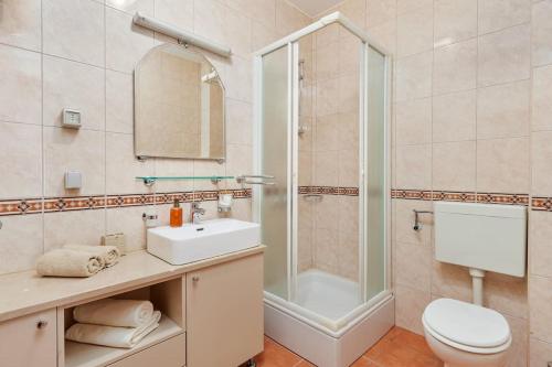 La salle de bains est pourvue d'un lavabo, d'une douche et de toilettes. dans l'établissement Spacious 1Bedroom on the Main Square of Kotor, à Kotor