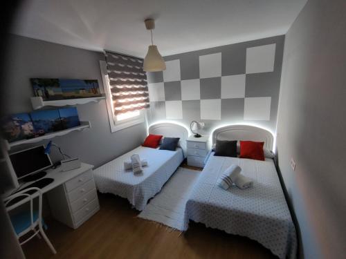 um pequeno quarto com 2 camas e uma secretária em El mirador de Mila en el corazón del Salnes VUT-PO-07707 em Cambados