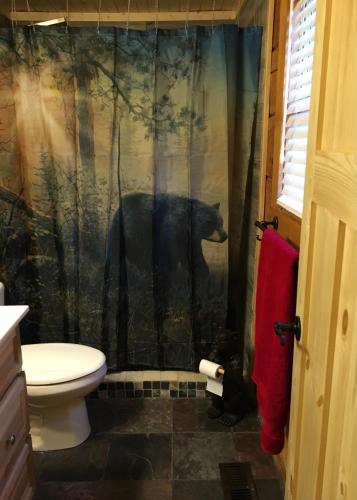 a bathroom with a bear in the shower curtain at Bears Among Us in Gatlinburg