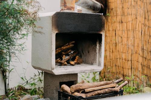 un horno al aire libre con una pila de madera. en Casa Vistas del Conde en Heredia