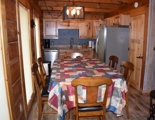 a kitchen with a table with chairs and a refrigerator at Bears Among Us in Gatlinburg