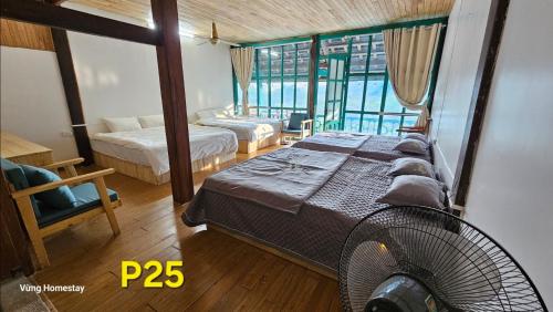 1 dormitorio con 2 camas y ventilador en Vừng Homestay - Mộc Châu, en Mộc Châu