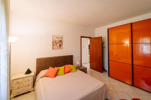a bedroom with a bed with orange and yellow pillows at Agriturismo Giù al Pozzo in Gavorrano