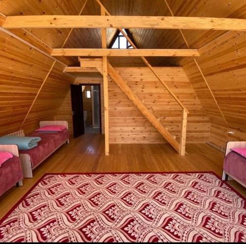 a room with two beds in a wooden cabin at Kolsay Village in Kurmenty