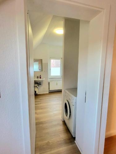 a kitchen with a washer and dryer in a room at Haus an der Weser - 24/7 Check-In in Heinsen