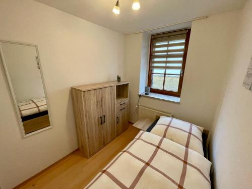 um quarto com uma cama, um armário e uma janela em Ferienwohnung Teichidyll Altenburg em Altemburgo