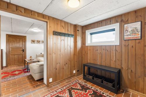 a living room with wood paneled walls and a fireplace at Stor og flott hytte med fantastisk utsikt in Geilo