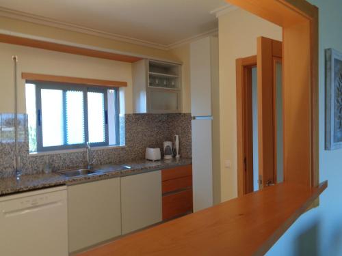 a kitchen with a sink and a window at Apartamento Arade Mar in Portimão