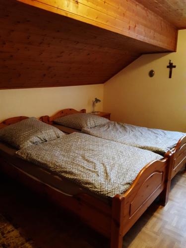 a bedroom with a wooden bed with a cross on the wall at Ferienwohnung Breuer in Plittersdorf