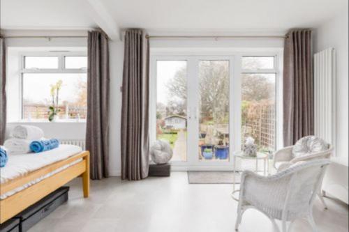 a bedroom with a bed and a large window at Oak Lodge in Poole