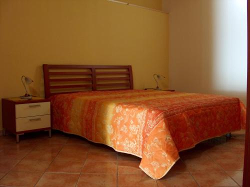 a bedroom with a bed and a nightstand with two lamps at Casale Vacanze in Siculiana