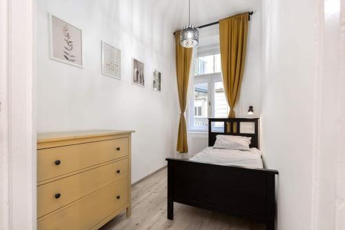 a bedroom with a bed and a dresser and a window at Perfect Day 3 -3 bedr, 2 bathrooms in Budapest