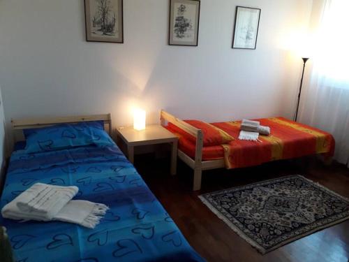 ein Schlafzimmer mit 2 Betten und einem Tisch mit einer Lampe in der Unterkunft Appartamento al Sole in Vicenza