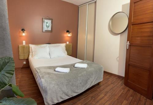 une chambre avec un lit avec deux serviettes dessus dans l'établissement Appartements de la houle, à Cancale