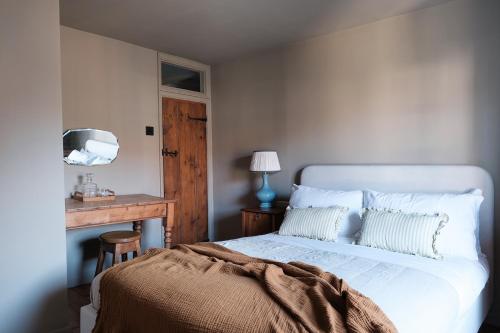 a bedroom with a white bed and a wooden table at Luxury family and dog friendly cottage in North Norfolk, Aylsham in Aylsham