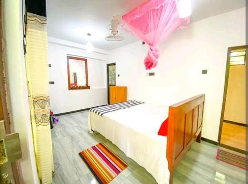 a bedroom with a bed with a pink umbrella at Yokel View Villa in Weligama