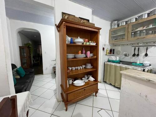 a kitchen with a shelf with dishes on it at Casa Saúde in Salvador