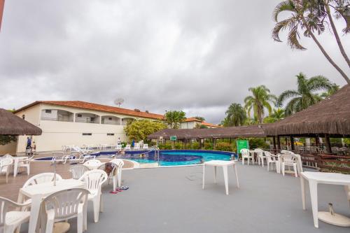 a resort with a pool and white tables and chairs at HOT SPRINGS HOTEL - BVTUR in Caldas Novas