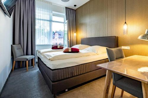 um quarto de hotel com uma cama grande e uma janela em Hotel Eydt Kirchheim em Kirchheim