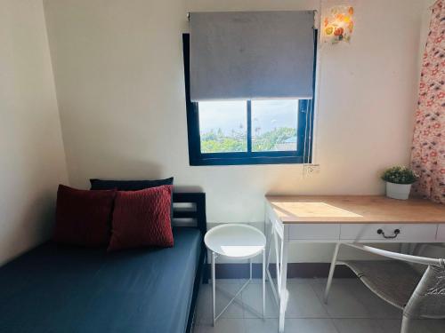 K.L.Apartment في تشالونج: غرفة بها أريكة ومكتب ونافذة