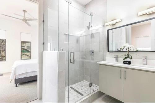 a white bathroom with a shower and a sink at Townhouse Uptown Private Patio in Dallas